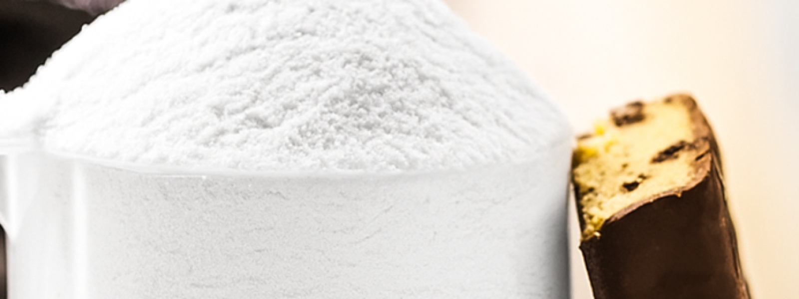 scoop of casein powder with protein bar